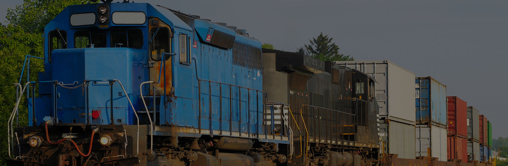 A train pulling more than a dozen containers is moving down the tracks.